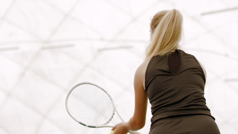 MED-SIDE-VIEW-Young-Caucasian-female-tennis-player-serving-during-a-game-or-practice.-120-FPS-slow-motion,-4K-UHD-RAW-graded-footage